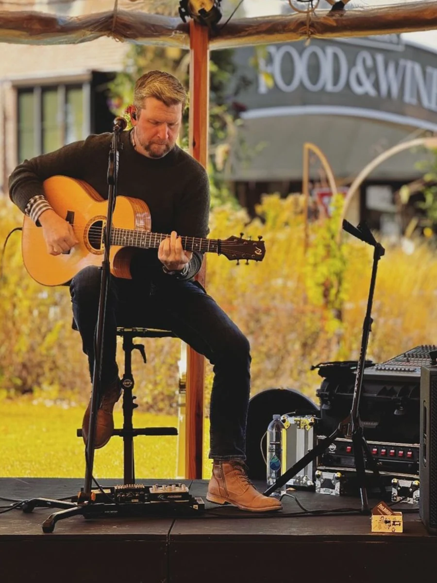 Phil Norby playing acoustic guitar and singing